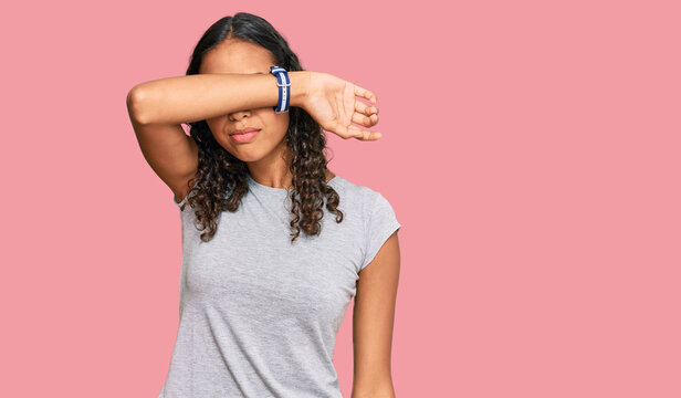 Young african american girl wearing casual clothes covering eyes with arm, looking serious and sad. sightless, hiding and rejection concept