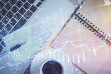 Stock market graph and top view computer on the table background. Double exposure. Concept of financial education.