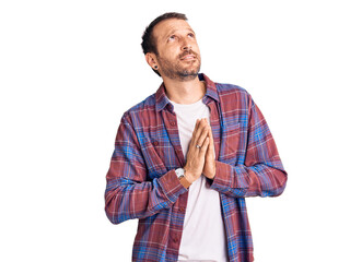 Young handsome man wearing casual clothes begging and praying with hands together with hope...