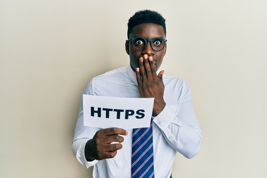 Handsome black man holding https privacy url covering mouth with hand, shocked and afraid for mistake. surprised expression
