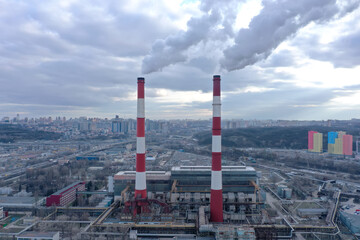 Pipes with white smoke. Pipes of a city gas boiler room with white smoke against a sky. Top view from a drone.	