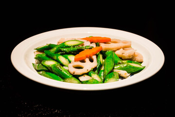 asparagus stir fried with lotus root and carrot serrved in a white plate