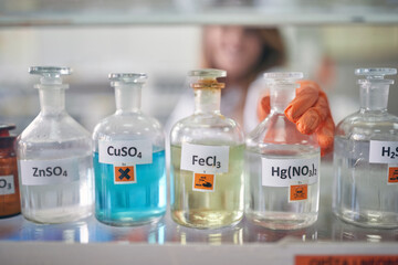 An institution employee handling bottles with chemicals in the laboratory. Chemistry, chemicals, lab