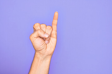 Hand of caucasian young man showing fingers over isolated purple background showing little finger...