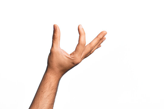 Hand of caucasian young man showing fingers over isolated white background picking and taking invisible thing, holding object with fingers showing space