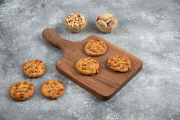 Tasty cookies with organic peanuts and honey on wooden board