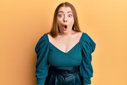 Young beautiful redhead woman wearing elegant and sexy look afraid and shocked with surprise expression, fear and excited face.