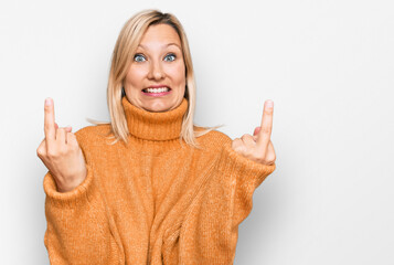 Middle age caucasian woman wearing casual winter sweater showing middle finger doing fuck you bad expression, provocation and rude attitude. screaming excited - obrazy, fototapety, plakaty