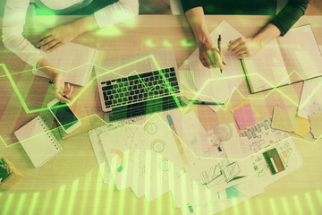 Double exposure of woman hands working on computer and forex graph hologram drawing. Top View. Financial analysis concept.