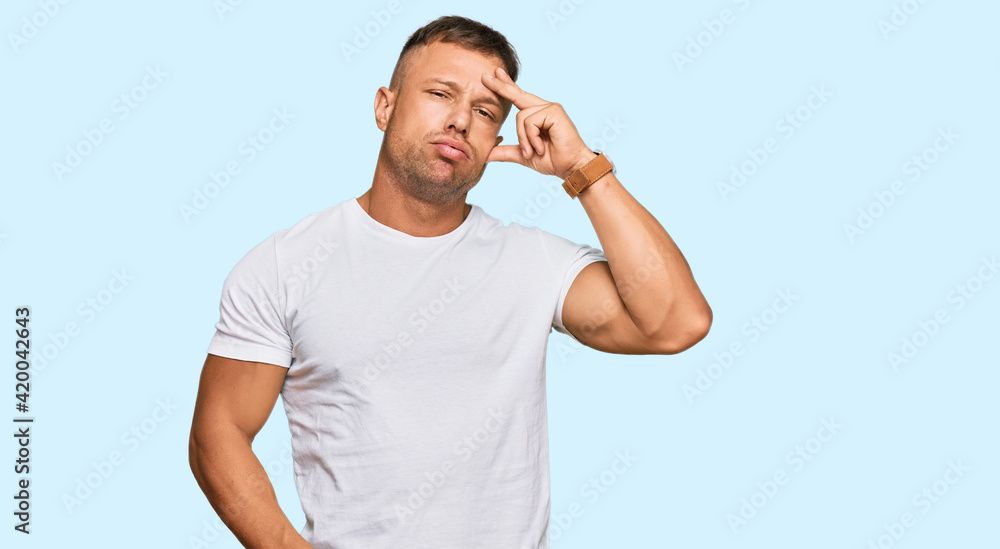 Poster Handsome muscle man wearing casual white tshirt worried and stressed about a problem with hand on forehead, nervous and anxious for crisis