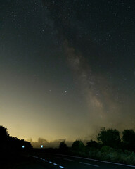Obraz na płótnie Canvas Dark road with Milky way galaxy. Night sky with stars.