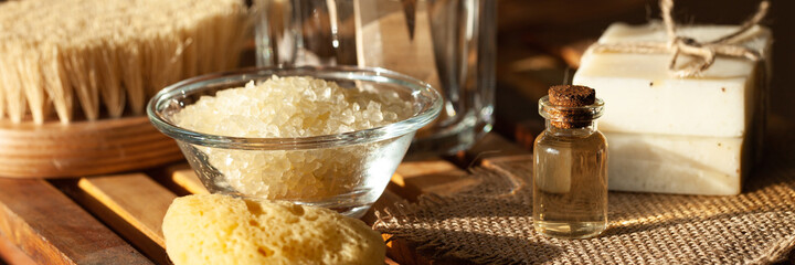 Zero waste and sustainable lifestyle concept. Eco-friendly bathroom accessories. Soap, organic essential oil, sea salt, wooden background. Home body, face care. Morning routine. Banner