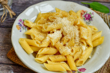  Home made  italian penne rigate pasta  with parmesan cheese,garlic  and black pepper .Pasta cacio e pepe. Mediterranean food concept