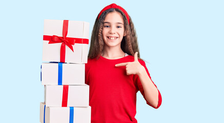 Cute hispanic child girl holding gift pointing finger to one self smiling happy and proud