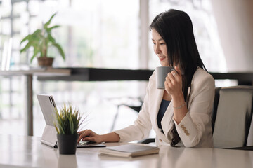 Businesswoman using digital tablet on workplace at office