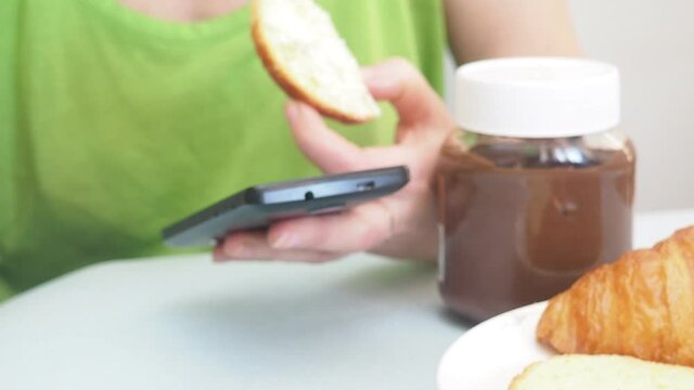 Coffee cup and fresh baked croissants, earphones, smart phone on white background. Top View. girl preparing breakfast in the kitchen. a cup of coffee, watching the news on the phone, communicating