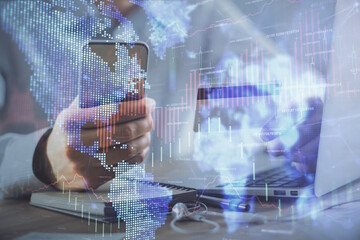 Obraz premium Double exposure of man hands holding a credit card and Forex graph drawing. Stock trading and digital fintech in Internet E-commerce concept.