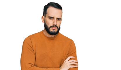 Young man with beard wearing casual winter sweater skeptic and nervous, disapproving expression on face with crossed arms. negative person.