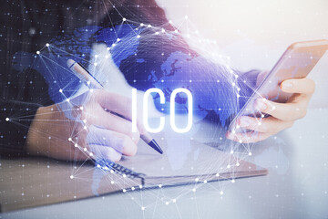Double exposure of blockchain business sketch hologram and woman holding and using a mobile device.