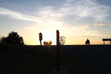 Silhouettes of people in the sunset swamp