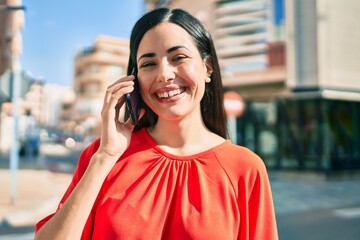 Young latin girl smiling happy talking on the smartphone at the city.