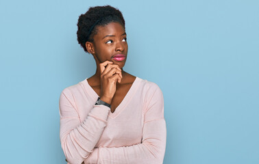 Fototapeta na wymiar Young african american girl wearing casual clothes with hand on chin thinking about question, pensive expression. smiling with thoughtful face. doubt concept.