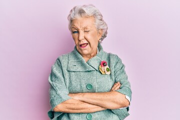 Senior grey-haired woman wearing casual clothes winking looking at the camera with sexy expression,...