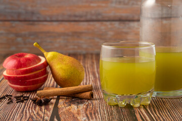 Green pear and red apple with a glass of juice