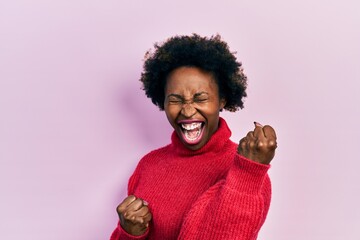 Fototapeta na wymiar Young african american woman wearing casual clothes celebrating surprised and amazed for success with arms raised and eyes closed