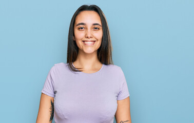 Obraz premium Young hispanic woman wearing casual clothes looking positive and happy standing and smiling with a confident smile showing teeth
