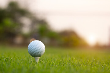 golf ball on tee in a beautiful golf course with morning sunshine
