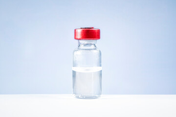 clear glass tube of liquid stands on a white table against a blue background. The concept of...