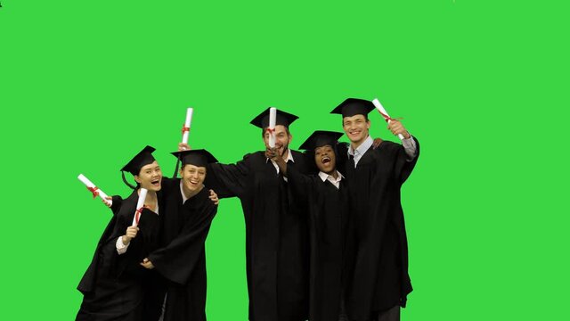 Happy students in graduation gowns posing for a picture on a Green Screen, Chroma Key.