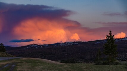 A beautiful red sunset over the mountains overgrown with coniferous forest. US