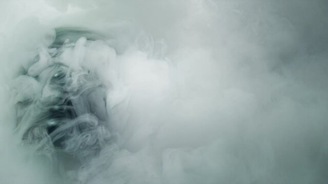 Curling smoke or fog covering black enigmatic mask, slow motion shot