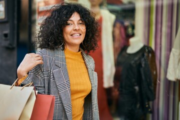 Young hispanic woman going shopping at the city.