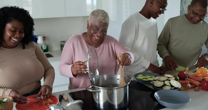 Happy latin family cooking inside kitchen at home - Father, daughter, son and mother having fun preparing lunch 