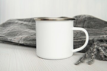 White enamel travel, camping mug mockup for design, warm cozy blanket.