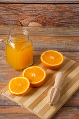 Orange juice in a glass jar on the wooden table