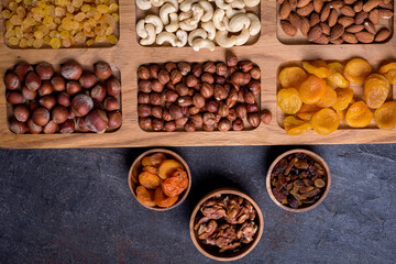 Obraz na płótnie Canvas Dried fruits and nut mix on wooden board, top view. Healthy snack