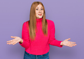 Young irish woman wearing casual clothes clueless and confused expression with arms and hands...