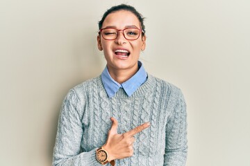 Young caucasian woman wearing casual clothes and glasses cheerful with a smile on face pointing with hand and finger up to the side with happy and natural expression