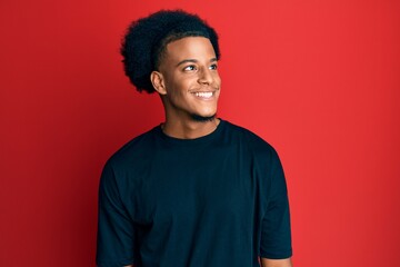 Fototapeta na wymiar African american man with afro hair wearing casual clothes looking to side, relax profile pose with natural face and confident smile.