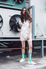 Teenager in white dress and green socks on the street