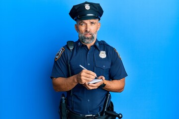 Middle age handsome man wearing police uniform writing traffic fine clueless and confused...