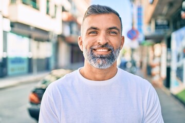 Middle age grey-haired man smiling happy standing at the city.
