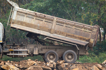 The truck is pouring stones. Pickup truck