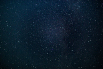 texture of the blue night sky and stars on a dark background. With noise and grain. Long-exposure...