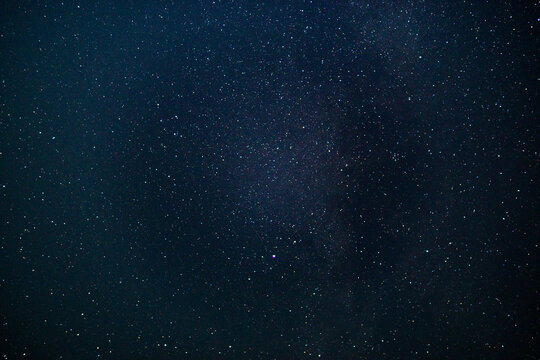 texture of the blue night sky and stars on a dark background. With noise and grain. Long-exposure photos.