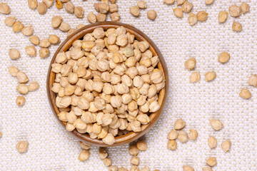Chickpeas in a wooden bowl on kitchen table. Raw chickpeas close-up. flat lay